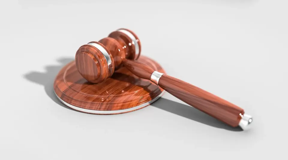 A wooden judge's gavel resting on a desk