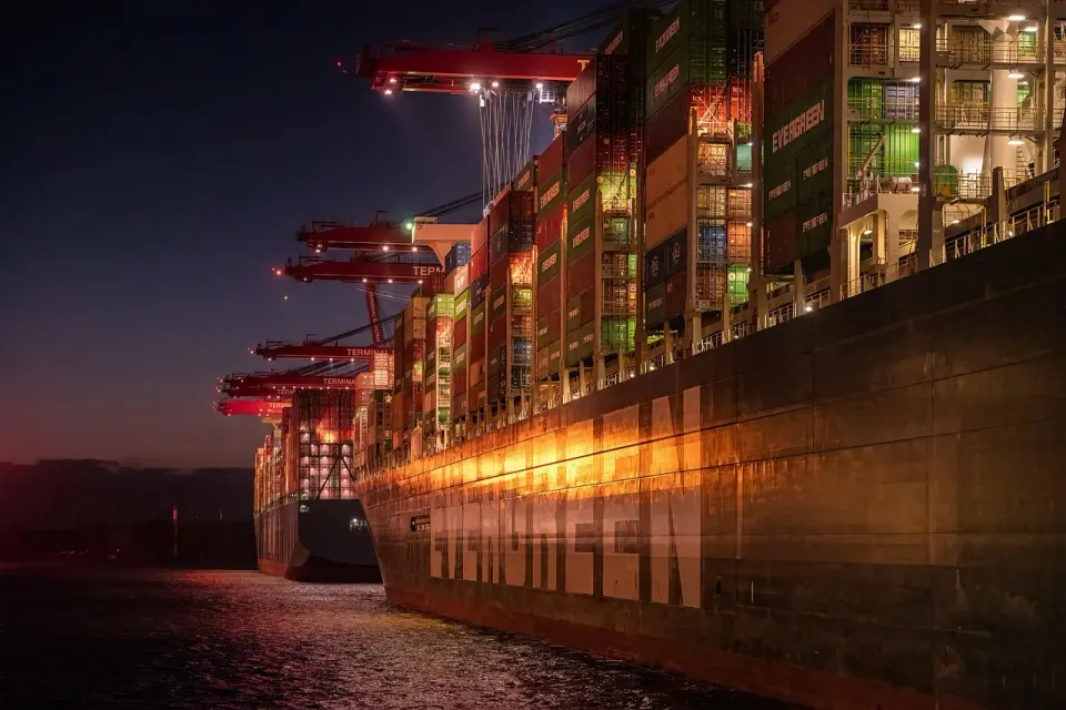 A container ship loading at a port terminal at night