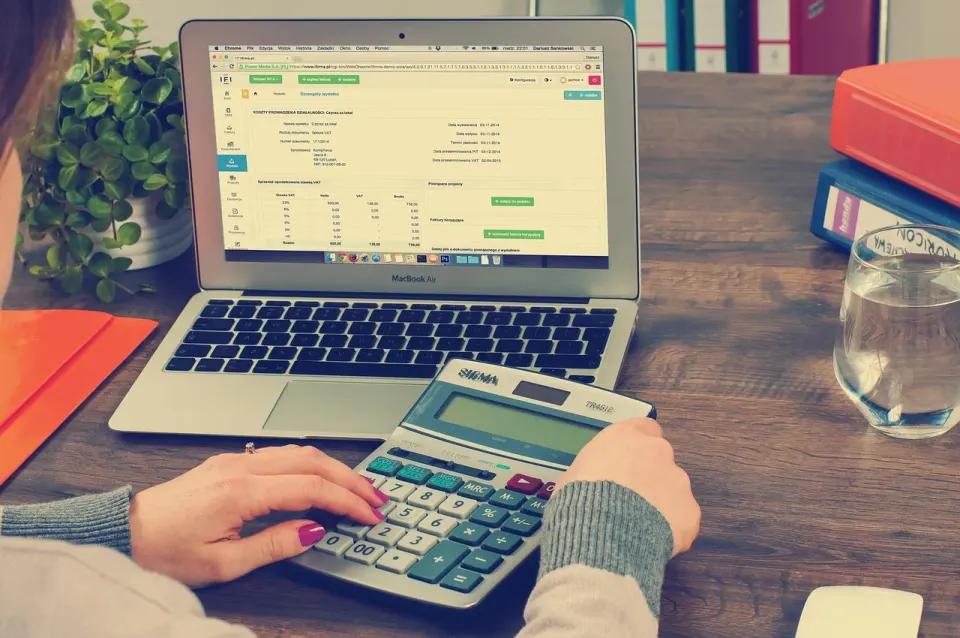 Invoices and a calculator on a desk during bookkeeping