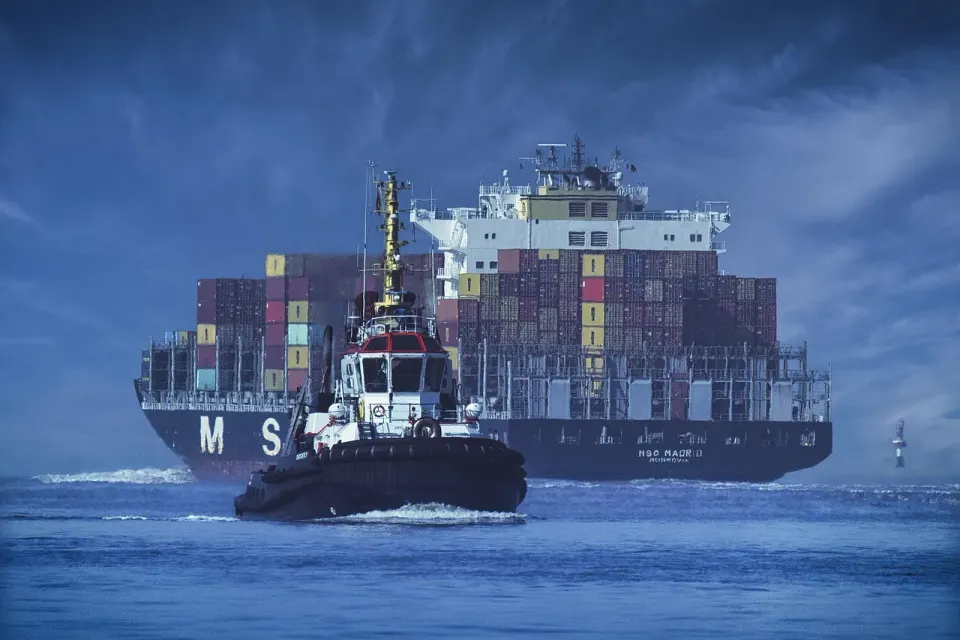 A container ship loaded with stacked shipping containers at sea